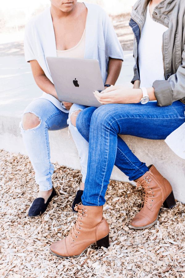 two friends with a laptop wondering how to get money fast.