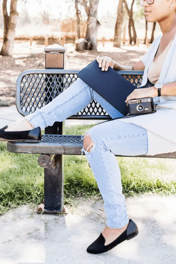 student sitting in a park with a book