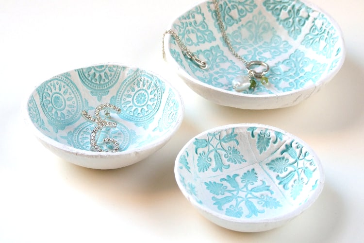 Three blue clay dishes with silver jewellery.