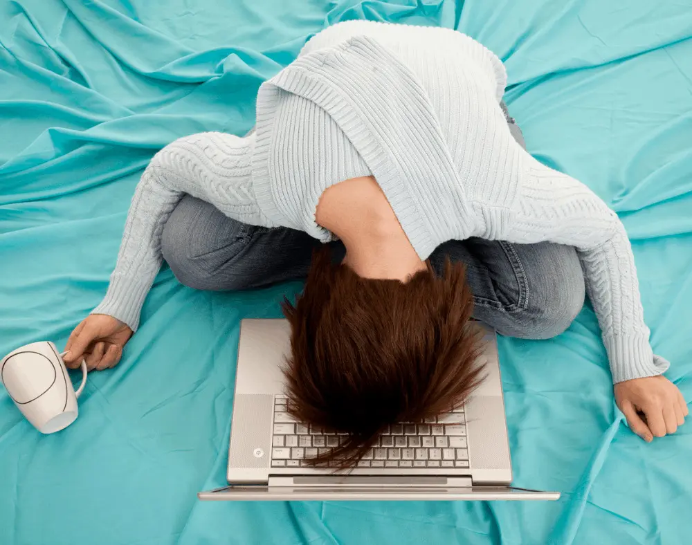 work from home jobs that don't suck. Woman tired on the bed with laptop.