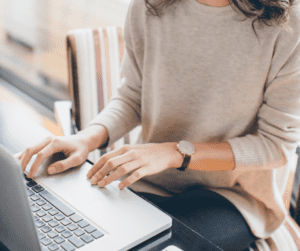 woman typing on a laptop to take part in Branded Surveys