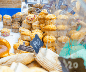 selling muffins at a cake stand.