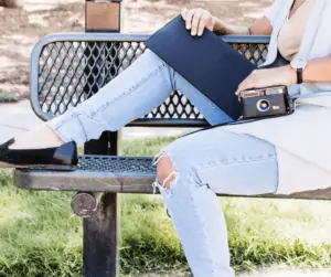 woman holding a folder and a camera.