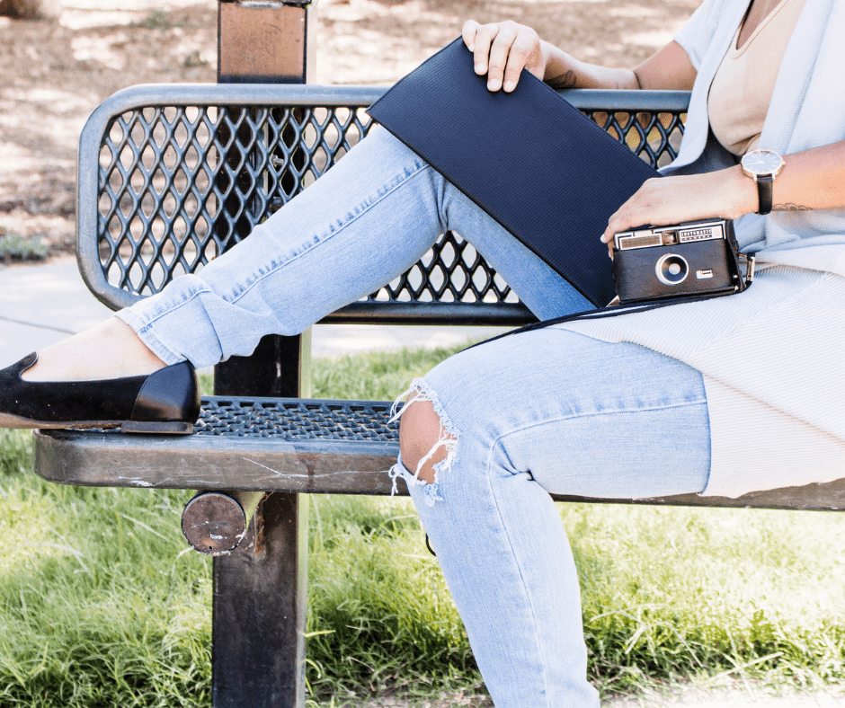 woman holding a folder and a camera.