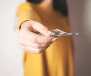 woman holding money - apps that pay instantly to PayPal